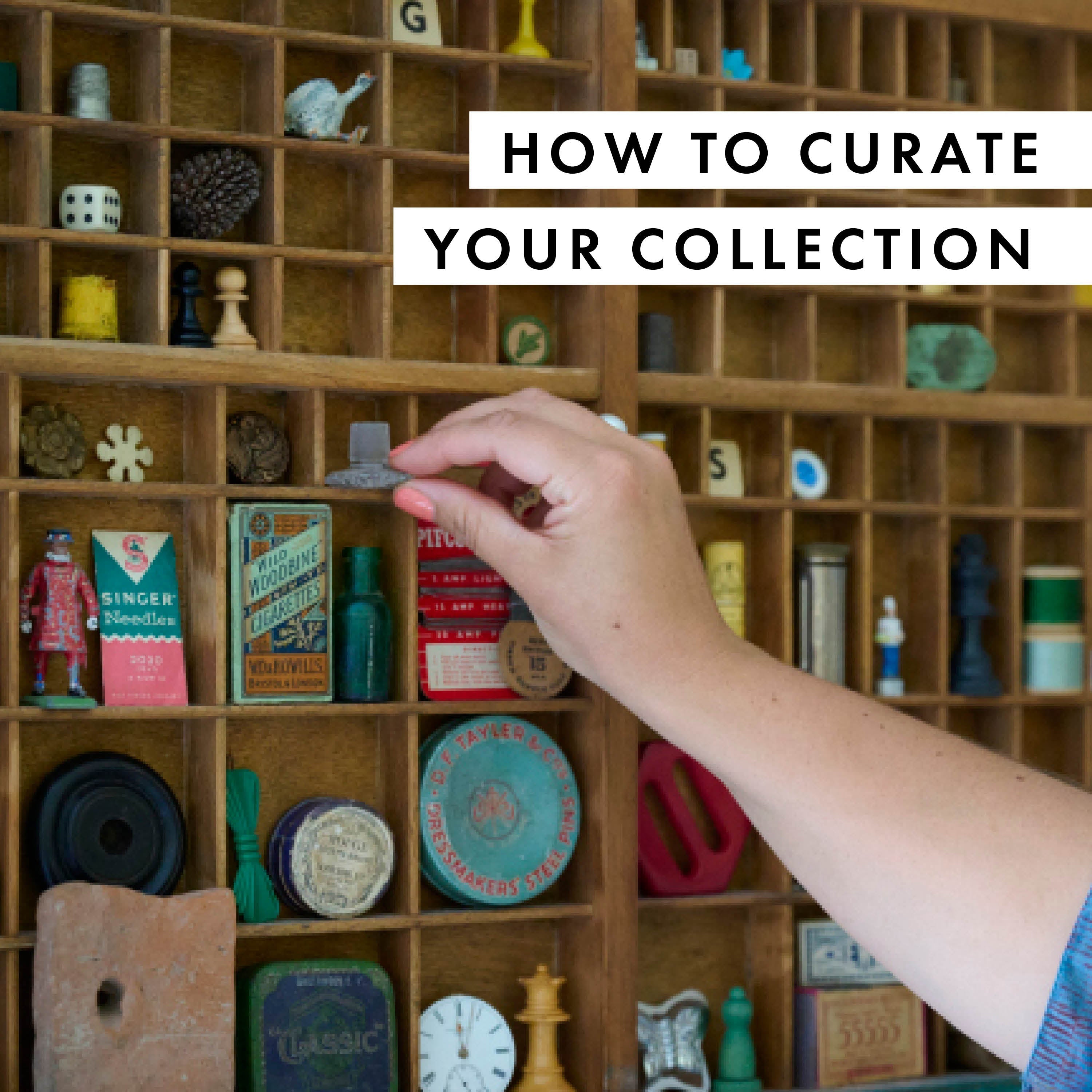 Image of a type tray with vintage collectables inside, hand reaching for one